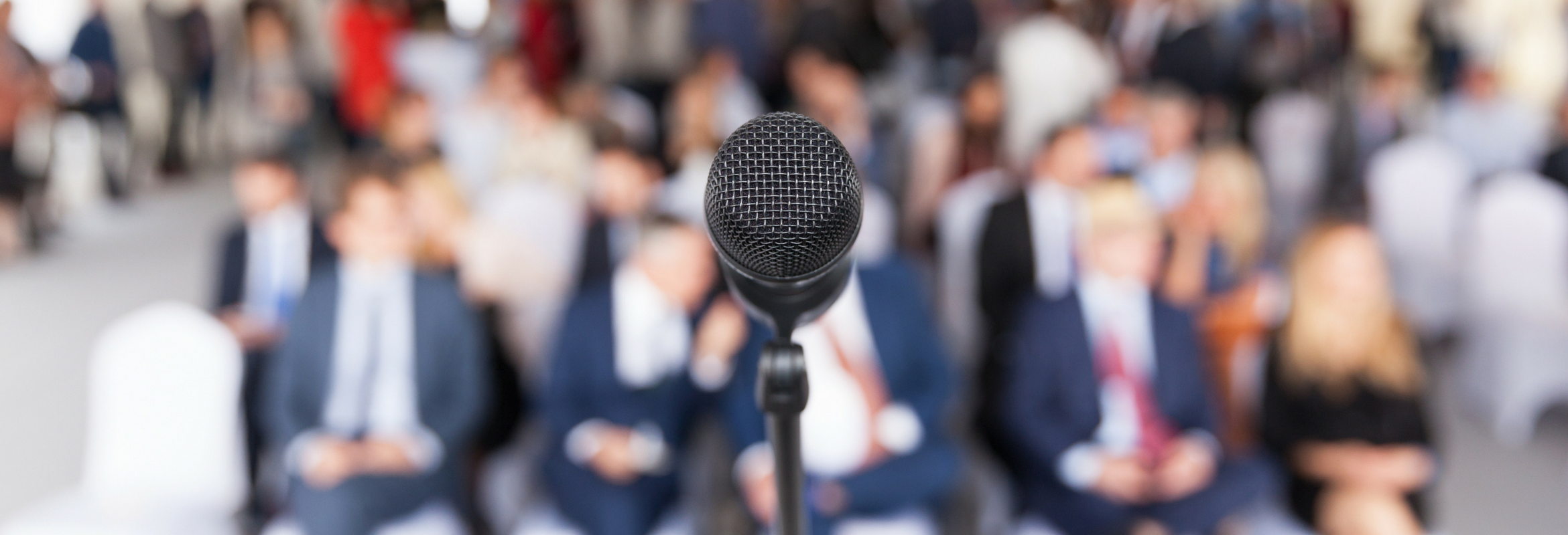 A microphone in a room of executives awaiting a presentation.